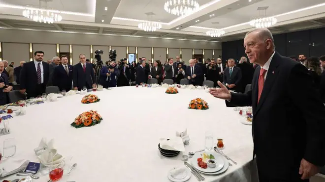 Cumhurbaşkanı Erdoğan yuvarlak bir masada çevredekileri selamlıyor