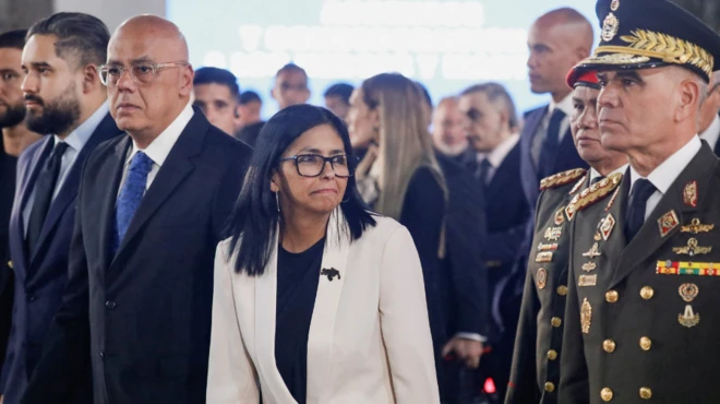 Delcy Rodríguez, con chaqueta blanca, flanqueada por altos dirigentes de la Venezuela chavista. 