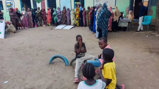 نساء نازحات من مدينة الفاشر يصطففن في طابور لتلقي المساعدات في مخيم بمدينة القضارف