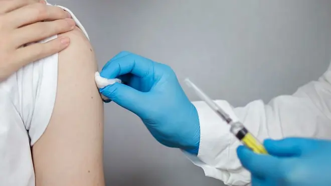 медсестра робить щеплення, видна рука пацієнтки