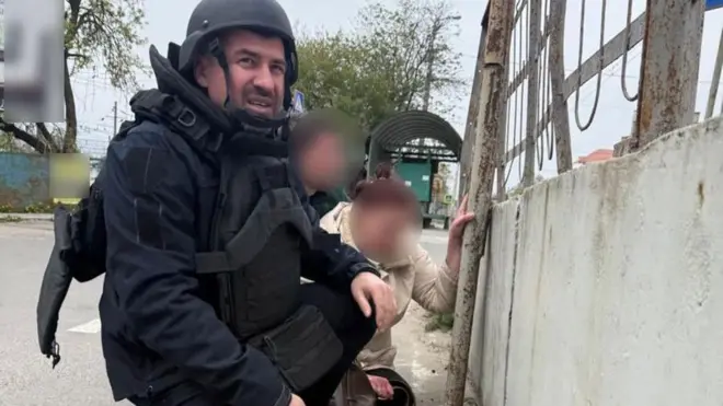 Поліцейський і люди ховаються під час атаки російських дронів 