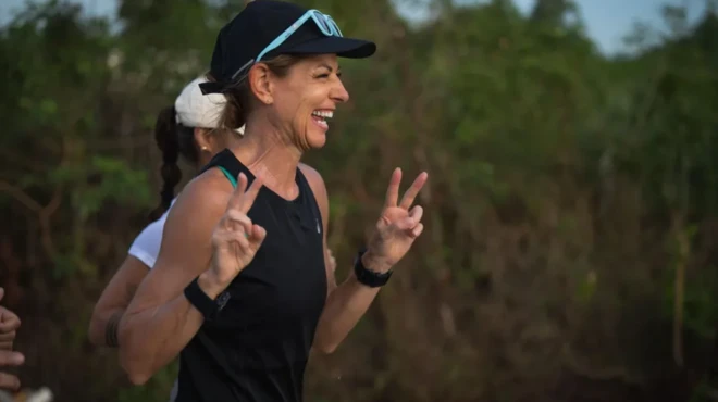 ناتالی در حال دویدن میخندد و انگشتش را به علامت پیروزی بالا برده