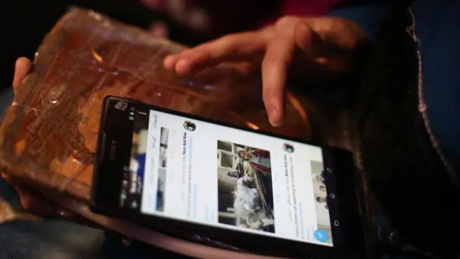 يد تمسك بهاتف جوال