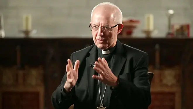 Justin Welby wearing a black blazer, glasses and clerical collar