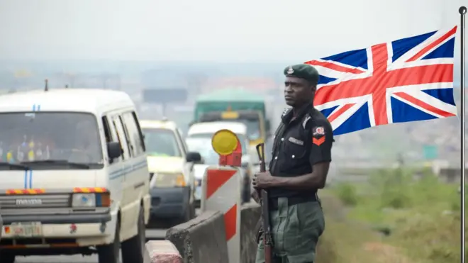Foto of traffic for Nigerian highway wit armed police officer and di UK flag