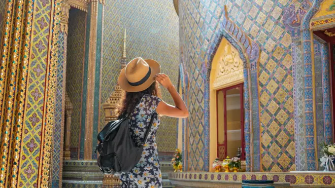 Mujer viajera en el templo Wat Ratchabophit en Bangkok en un día de verano.