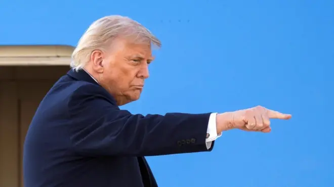 President Donald Trump gestures as he boards Air Force One