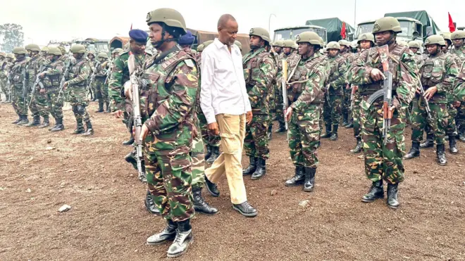 Elias Magosi (wambaye ishati y'umweru) anyura mu ngabo za Tanzania ziri mu mutwe wa SADC i Goma ku cyumweru
