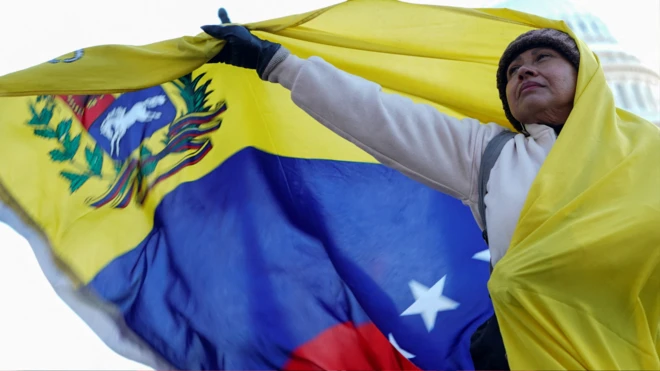 Mujer envuelta en una bandera de Venezuela grande