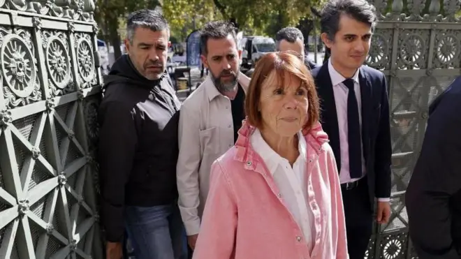 Žizel Peliko, u roze jakni i beloj košulji ispod, ulazi u sud dok su iza nje muškarci 