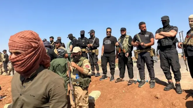 Bedeviler sırayla dizilmiş savaşçıların önünde yüzünü sarmalamış bir savaşçı duruyor. 