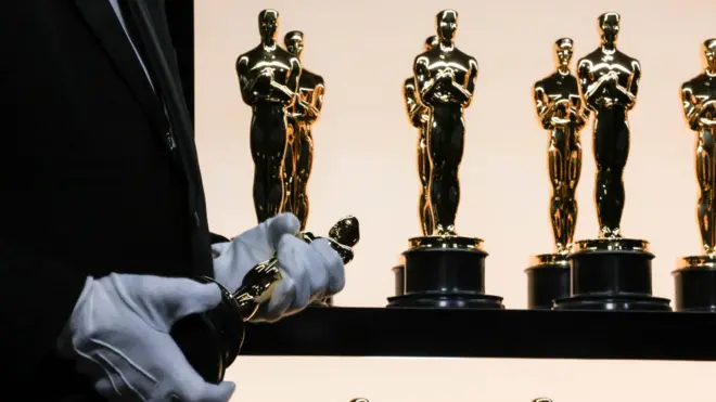 Dem go display di Oscar statuette for di backstage during di show 