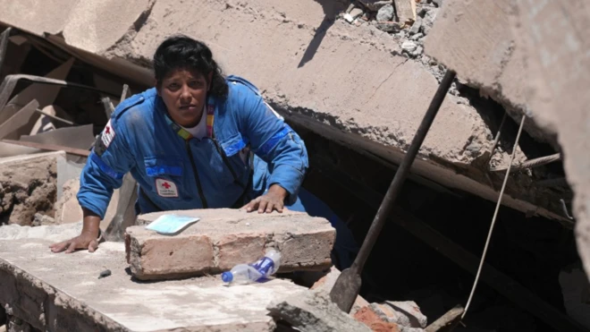 Un miembro de la Cruz Roja colombiana busca entre los escombros de un edificio derrumbado en Cali.