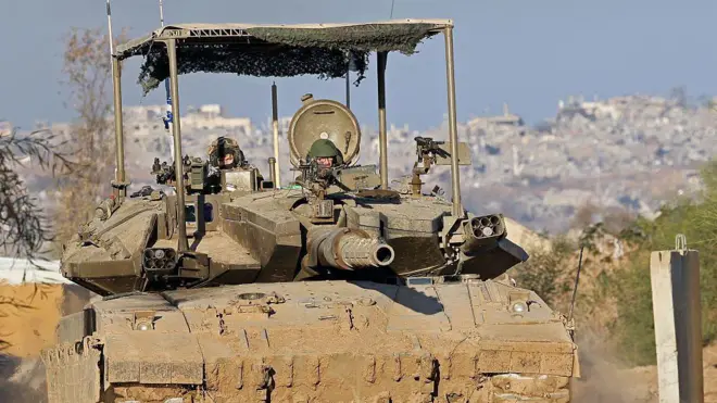 الصورة تظهر دبابة إسرائيلة متجهة إلى غزة ويبدو بارزا طاقمها في برج قيادتها