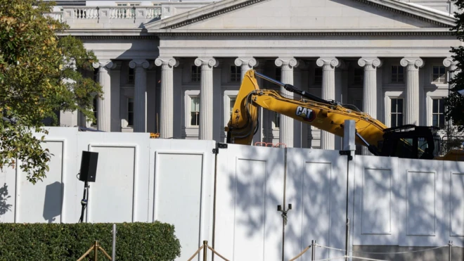 Строительная техника за забором, огораживающим Белый дом. Видно здание с колоннами
