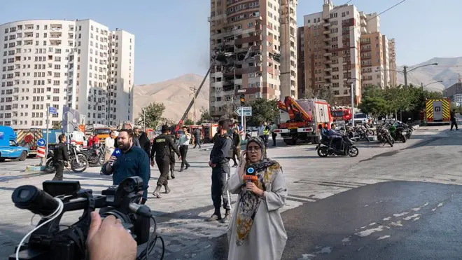 گزارشگران تلویزیون در حال گزارش از حمله اسرائیل به یک ساختمان هستند 