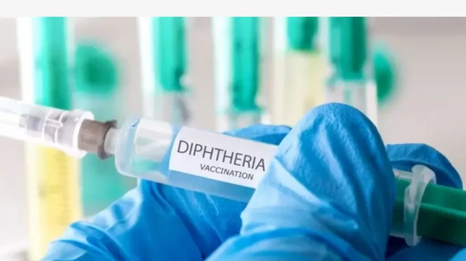 Aworan ọwọ wọ ibọwọ, to mu abẹrẹ ajẹsara to n dena Diphtheria dani
