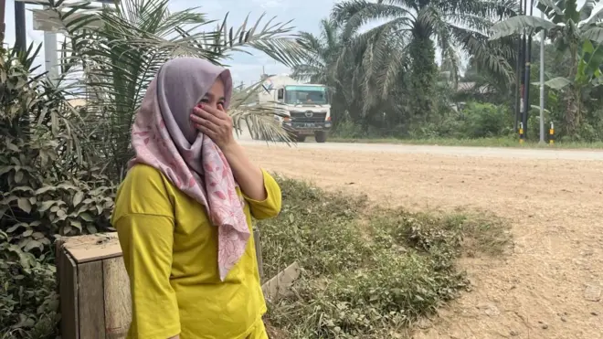 Syarariyah menutup hidungnya akibat debu yang ditimbulkan truk-truk ke IKN.