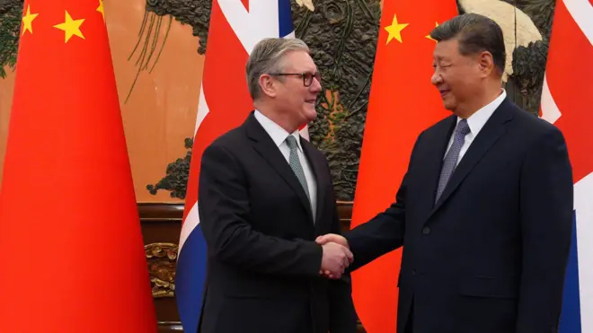 施紀賢（左）與習近平（右）在北京人民大會堂握手，背景是兩國國旗（29/1/2026）