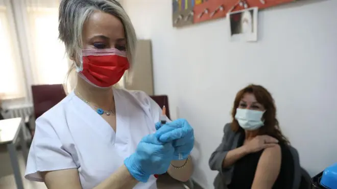 Aşı yapan bir hemşire ve aşı olan bir yurttaş