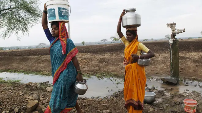 पाण्याचा हंडा डोक्यावर घेतलेल्या महिला