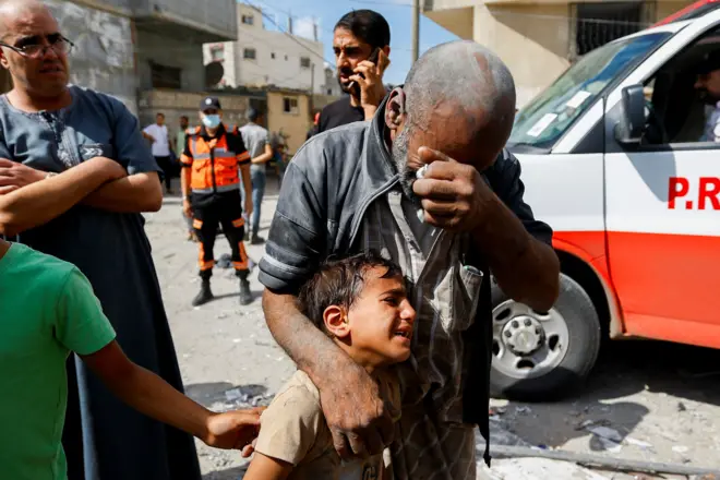 Homem e criança chorando após ataque aéreo israelens