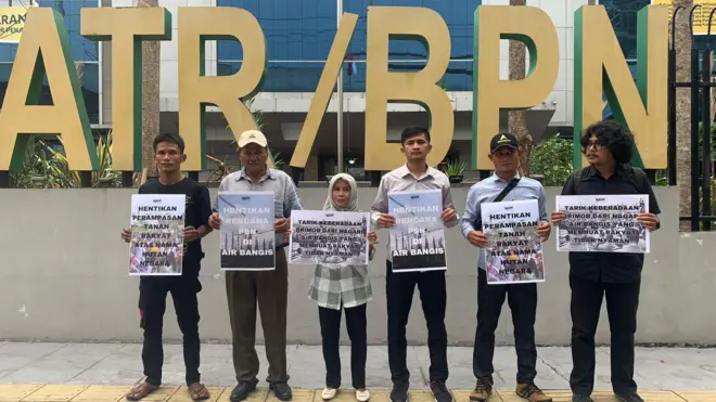 Sejumlah warga Air Bangis dan aktivis lingkungan memegang poster di depan gedung Kementerian ATR/BPN untuk memprotes perampasan lahan rakyat