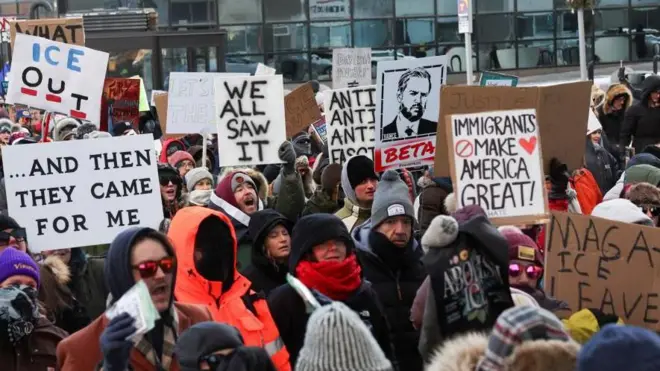 防寒具に身を包んだ人々がプラカードを持って更新している。J・D・ヴァンス副大統領の似顔絵の下に「BETA」と書いたプラカードを持っている人もいる