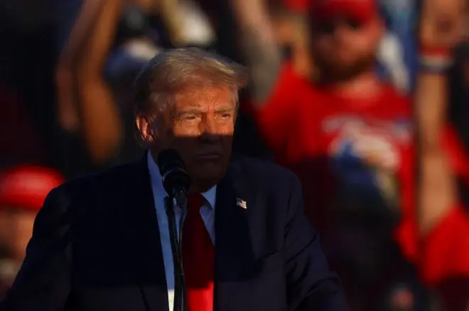 Доналд Трамп у плавом сакоу за говорницом на једном од предизборних скупова