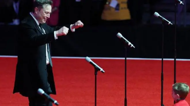 إيلون ماسك وأحد أطفاله وبينهما خمس مايكروفونات