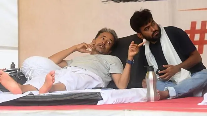 শুয়ে থাকা সোনাম ওয়াংচুক একহাতের আঙুল তাক করে পাশে বসা অভিজিৎ দীপকেকে কিছু দেখাচ্ছেন