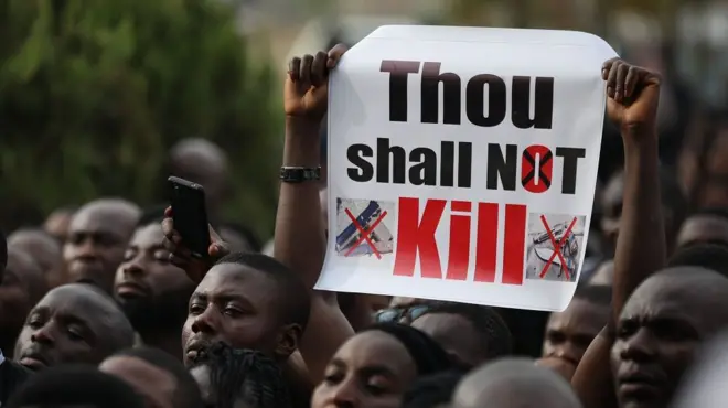 Christians faithfuls hold signs as they march on the streets of Abuja during a prayer and penance for peace and security in Nigeria in Abuja on March 1, 2020 - they are holding a sign that says 'thou shall not kill'