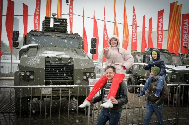 Семья на выставке украинской военной техники, захваченной российскими войсками в ходе войны 