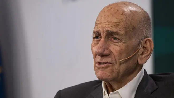 Ehud Olmert con una chaqueta oscura y una camisa blanca.