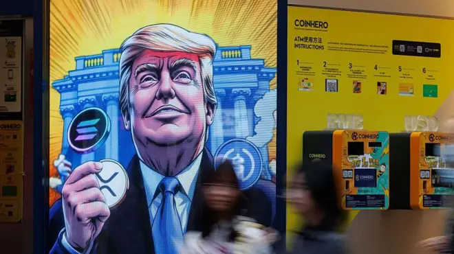 人們走過香港一則以特朗普 (Donald Trump) 和比特幣為主題的廣告。