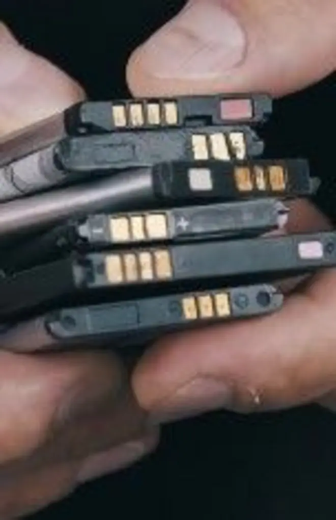Uma mão segurando baterias de celular