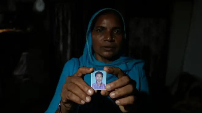 बिरनपुर गांव में तीन दिनों में तीन मौतें. मारे गए ईदुल मोहम्मद की तस्वीर लिए उनकी पत्नी शकीला बी.