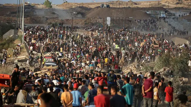 Palestinians gather at an aid distribution point set up by the privately-run Gaza Humanitarian Foundation (GHF), near the Nuseirat refugee camp in the central Gaza Strip on June 25, 2025. 