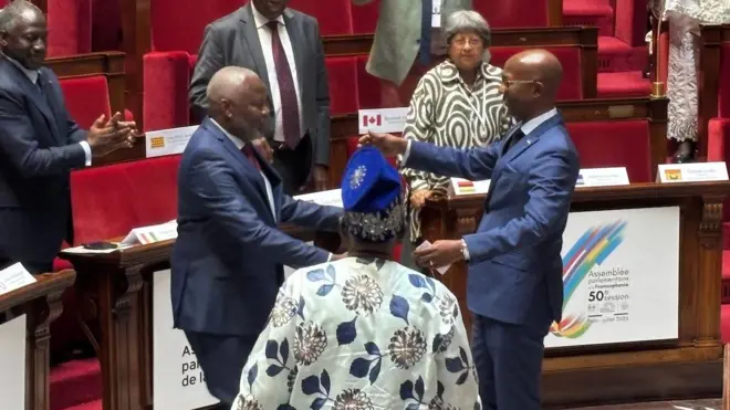 Vital Kamerhe (ibumoso) na Mussa Fazil Harerimana bagiye guhoberana imbere y'ihuriro ry'abagize inteko zishingamategeko zo mu bihugu bigize umuryango wa Francophonie