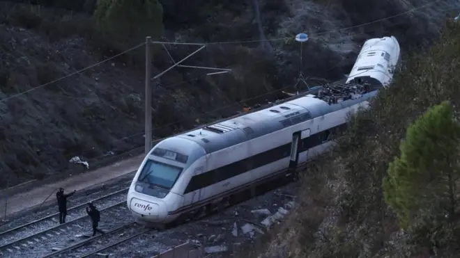 Members of the Spanish Civil Guard work next to one of the trains involved in the accident