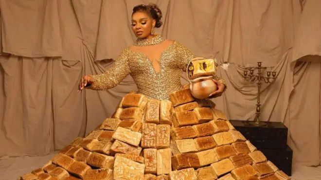 Mercy Atang wọ aṣọ agbekọ oniburẹdi, o si gbe ikoko lọwọ