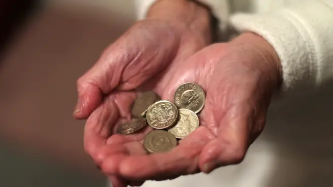 U rukama starije žene metalni novčići