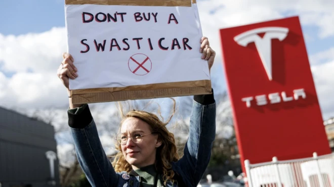 Una mujer protesta contra Tesla y Elon Musk en Reino Unido.