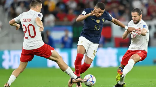 France forward Kylian Mbappe dey try beat two Polish defenders