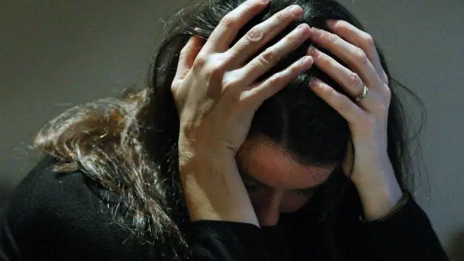 頭をかかえる女性