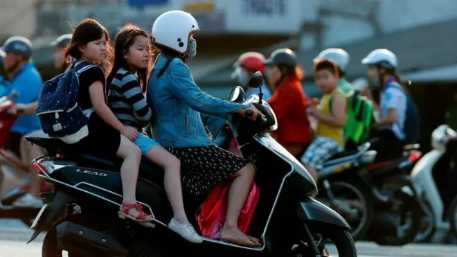 Học sinh tiểu học được cha mẹ chở đến trường 
