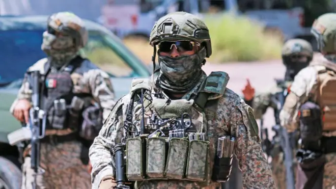 Un soldado del ejército de México con la cara cubiera y vestido de uniforme