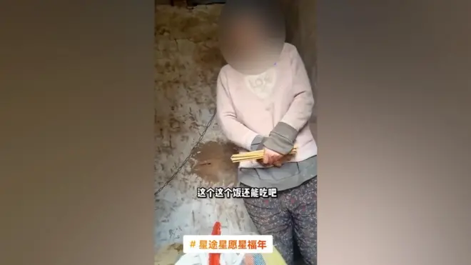 A screenshot from the video shows the woman with a chain around her neck