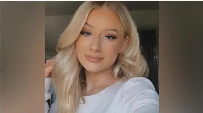 露西・哈里森顶着披散的金色长发，对着镜头露出微笑