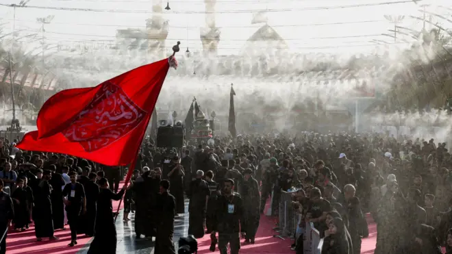 تجمع لمسلمين شيعة قبل عاشوراء أقدس الأيام الدينية عندهم في كربلاء في العراق وسط رش للماء للتبريد على وقع درجات حرارة مرتفعة 